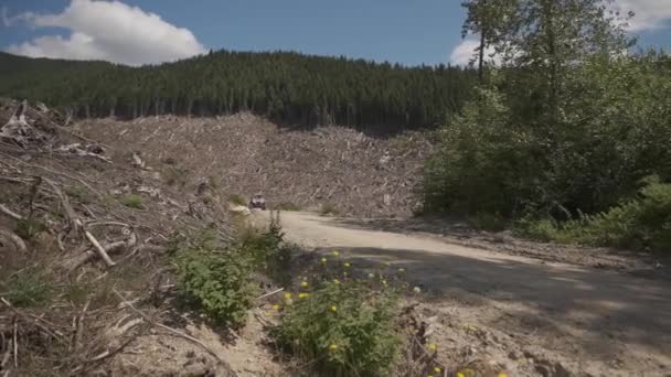 在林地地区 四驱车与四轮驱动的越野车并排高速通过道路上的泥土 在白天留下一道道灰尘 — 图库视频影像