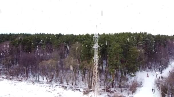 High Voltage Electric Pole Standing Forest Heavy Snowfall Aerial Descend — Vídeos de Stock