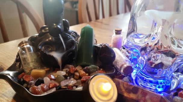 カラフルな癒しの結晶と木製のキッチンテーブルの上の神秘的な香の精神的な頭蓋骨のコレクション — ストック動画