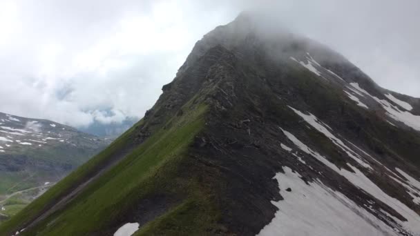 Drone Shot Rotating Dark Mountain Partially Covered Snow Clouds — Vídeos de Stock