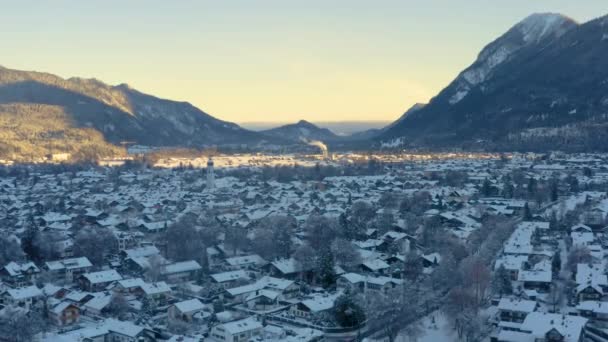 山の影に雪のGarmisch Partenkirchen町 ドローンショット — ストック動画