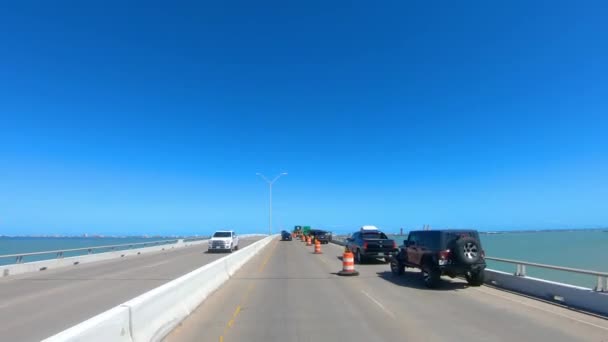 在南帕德雷岛和得克萨斯州伊莎贝尔港之间的伊莎贝拉女王铜道开车经过公路建设 在南得克萨斯州阳光明媚的日子在拉古纳 马德雷的堤道桥 — 图库视频影像