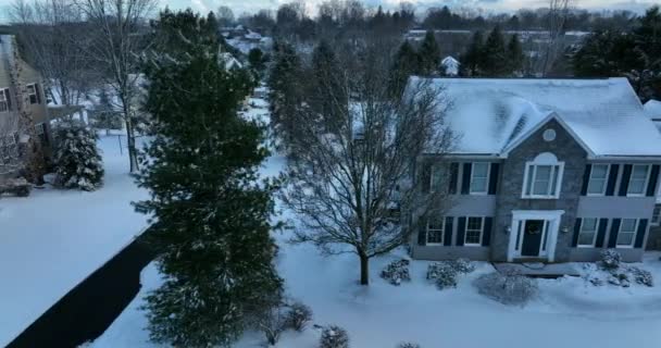 American suburban homes in winter snow. Aerial truck shot at night with fresh snowfall.