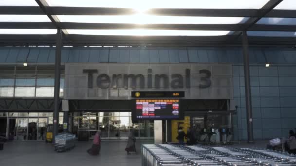 Row Baggage Trolleys Heathrow Terminal Building Airline Departure Board Sun — ストック動画