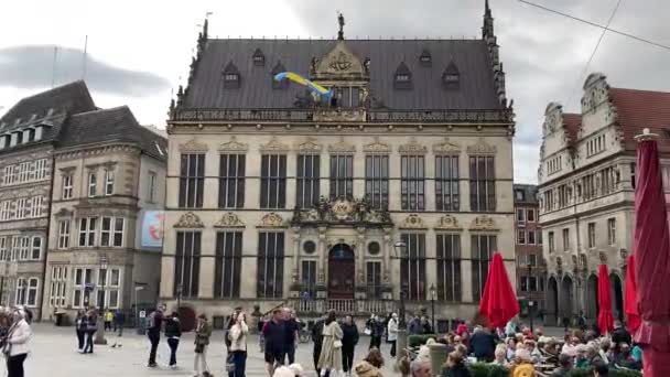 ウクライナの旗は ハウススケット 観光客の群衆とブレーメン市場広場に飛んで — ストック動画