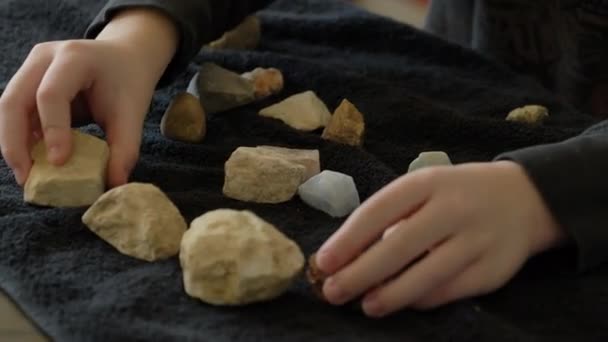 Een Jonge Jongen Kijkt Naar Zijn Rock Collectie Een Handdoek — Stockvideo