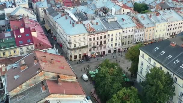2021年夏の日没時に旧ヨーロッパ様式の建物に囲まれたウクライナの通りを歩く人々の空中ビュー — ストック動画