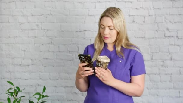 Blonde Beautician Texting Her Phone While Holding Coffee Her Break — Vídeo de Stock