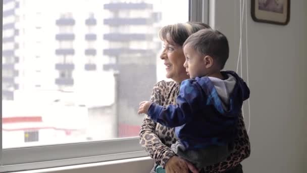 Latin Grandmother Her Grandson Looking Out Window Mexico City — стоковое видео