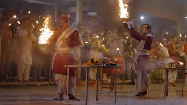 Hinduističtí kněží s ohněm lampy během svaté Gangy Aarti rituál v Triveni Ghat, Rishikesh, Indie v noci. plný výstřel