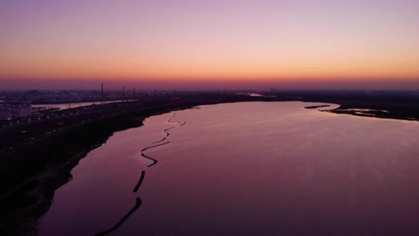 反射したオレンジの夕日の色で穏やかな水路を越える空中マアスベイト工業港のシルエットの景色の隣にあります ドリー バック — ストック動画