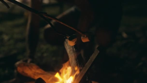 Marshmallows grilované na otevřeném ohni dřevěnými holemi, v noci - zpomalený výstřel