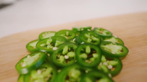 Slow Motion Drift Över Ljusa Gröna Högen Nyskivad Jalapeos Skärbräda — Stockvideo