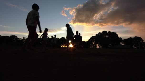 アマゾンの熱帯雨林でサッカーをしている子供たちのシルエットは素晴らしい日没の間に — ストック動画