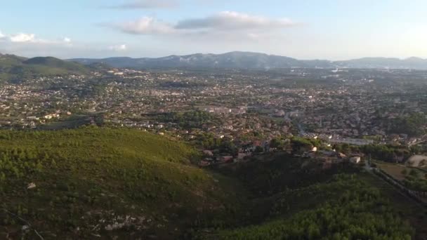 青空の下 丘や山を背景にした地中海の村のドローンショット 一日の終わり — ストック動画