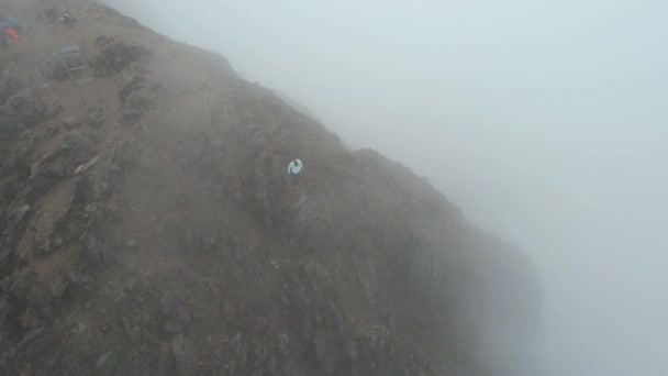 濃い霧の中で山の上に人間の鳥の目の空中ビューは 極端な条件で登山 エクアドルのRucu Pichincha火山サミット — ストック動画