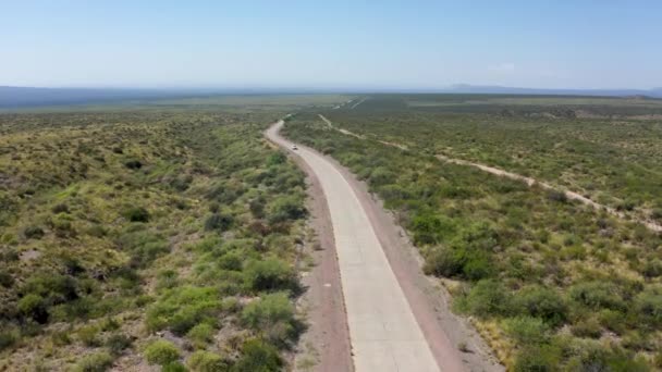 Único Carro Branco Viajando Estrada Longa Estreita Vasto Deserto Árido — Vídeo de Stock
