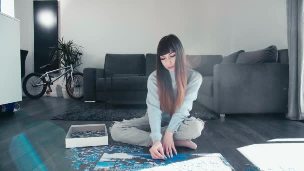 Young Woman Sitting Cross Legged Assembling Puzzle Her Leisure Time — Vídeo de Stock