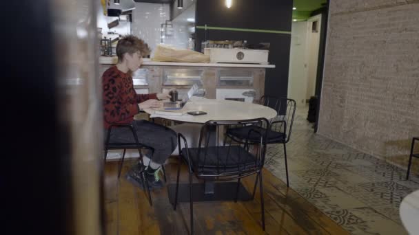 Rövid Hajú Kávét Iszik Számítógépet Használ Üres Étteremben — Stock videók