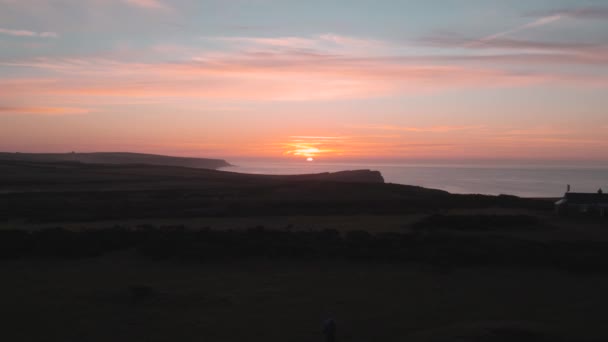 Aerial Pan Out Coastal Cliff Reveal Orange Sunset Backdrop Rhossili — Stockvideo