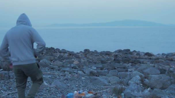 Male Youth Throws Plastic Seaside Shoreline Pocket — стоковое видео