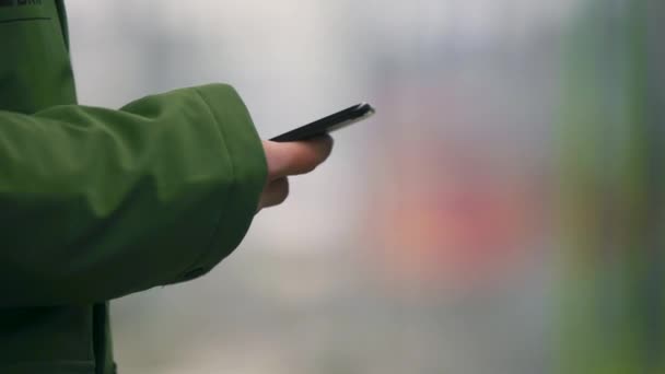 Hand Green Jacket Sleeve Scrolling Smartphone Blurry Background Close Train — Vídeos de Stock