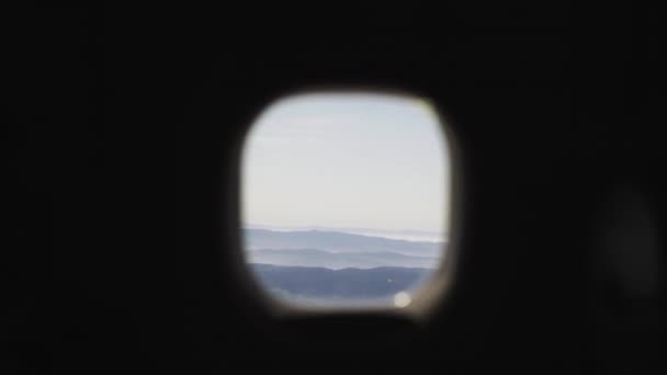 Airplane Window Manoeuvre Revealing Clear Blue Sky Scenic Mountain Landscape — Stock Video