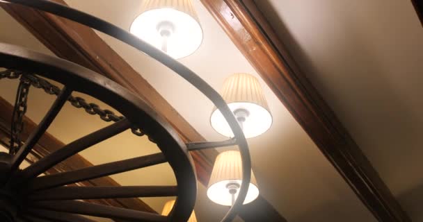 天井にぶら下がっているアンティークシャンデリアの光る電球 低角度 スライドショット — ストック動画