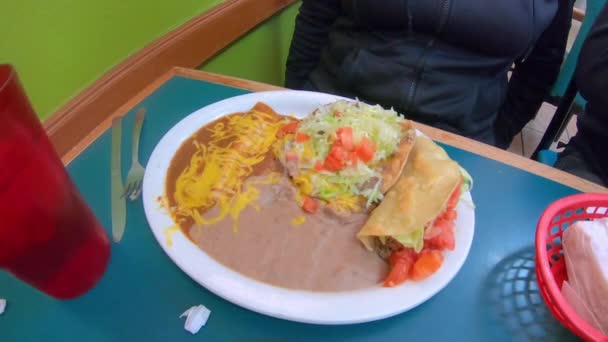 地元のメキシコ料理レストランでのランチスペシャルには 牛肉タコ シャルーパ エンチラーダチーズと揚げ豆が含まれています レストラン エスニック料理 友情と家族の概念 — ストック動画