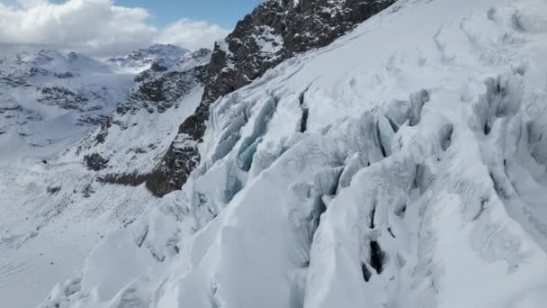 在阿尔卑斯山的一个阳光明媚的冬天 空中飞行俯瞰着一座大冰川表面的裂缝 — 图库视频影像