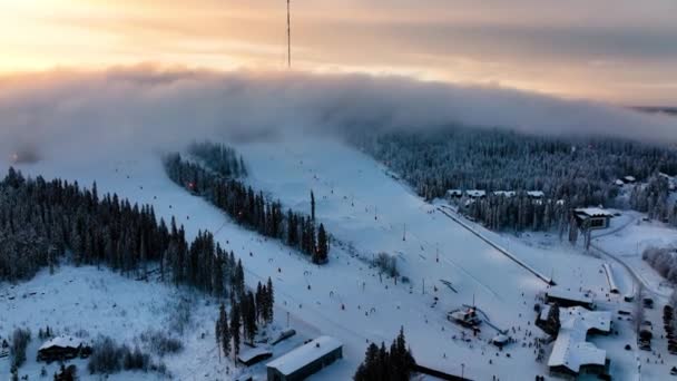 空中ビューの人々は フィンランドの夕日 ブオカッティの斜面で下り坂スキー ドローンショット — ストック動画