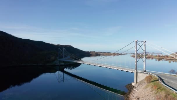 从空中俯瞰峡湾上方的特隆赫鲁门桥 农场和房屋分散在海岸上 地平线上的山塔 — 图库视频影像