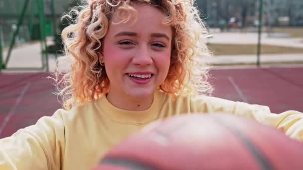 Adolescente Rubia Caucásica Sosteniendo Baloncesto Patio Recreo Sonriendo Cámara Movimiento — Vídeos de Stock