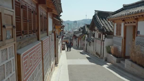 韓国ソウルの晴れた日にブチョン韓屋村のブチョン路11キル通りを旅する人々のグループ — ストック動画