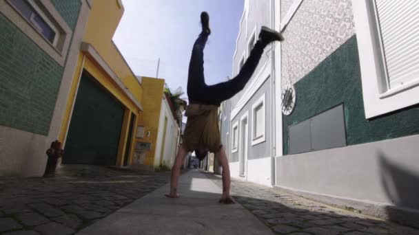ポルトガルのポルトガル市内中心部にある狭い通りに立つ若い運動能力のある白人観光客の男性は 彼の夏休みの間の幸せな生活を祝う — ストック動画