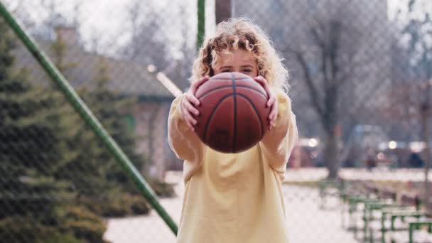 Happy Teenage Caucasian Blonde Girl Holding Basketball While Looking Camera — Vídeos de Stock