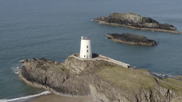 Ynys Llanddwyn岛上Twr Mawr灯塔的航拍图 在灯塔周围从左到右飞行 同时在英国威尔士北部的安吉塞岛扩大视野 — 图库视频影像