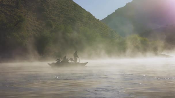 Landscape view of fishermen fishing on a boat surrounded by dense fog on Limay River in Patagonia, Argentine.