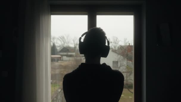 Estudiante Escuchando Música Mientras Mira Por Una Ventana — Vídeo de stock