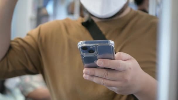 Asian Man Using Smartphone While Hands Holding Handrail Grip Straps — Stockvideo