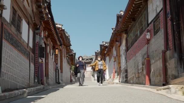 韓国ソウルのブチョン韓屋村でマスク旅行をしているシニア韓国人女性 — ストック動画
