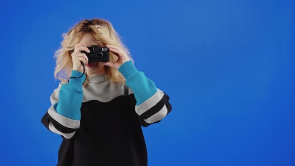 Chica Adolescente Rubia Tomando Fotos Con Cámara Cine Fondo Estudio — Vídeos de Stock