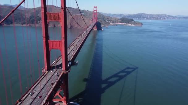 雲一つない日の間 カリフォルニア州サンフランシスコのゴールデンゲートブリッジに沿って高く飛ぶドローン — ストック動画