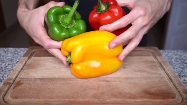 Närbild Person Sätta Röd Grön Och Gul Paprika Träskiva Köket — Stockvideo