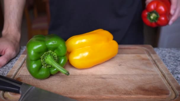 Κόκκινες Πράσινες Και Κίτρινες Πιπεριές Ξύλινη Σανίδα Έτοιμες Για Μαγείρεμα — Αρχείο Βίντεο