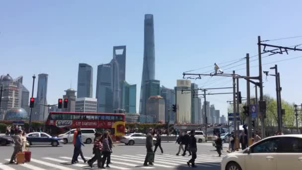 浦東のスカイラインや上海世界金融センターや上海タワーのような高層ビルと黄浦川の前を横断するゼブラクロスの人々 — ストック動画