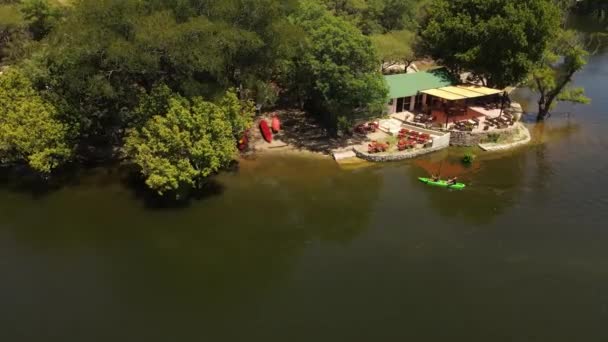 Couple Paddling Kayak Restaurant River Bank Cordoba Argentina Aerial Orbiting — ストック動画