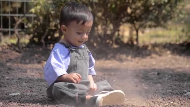 Liten Latinsk Pojke Som Sitter Marken Och Leker Med Jorden — Stockvideo