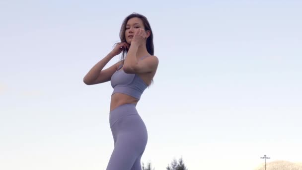 Asiatisk Modell Drar Håret Tillbaka Bär Sport Behå Och Leggings — Stockvideo