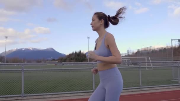 Mixed Race Asian Woman Jogging Track Slow Motion Profile — Stock Video
